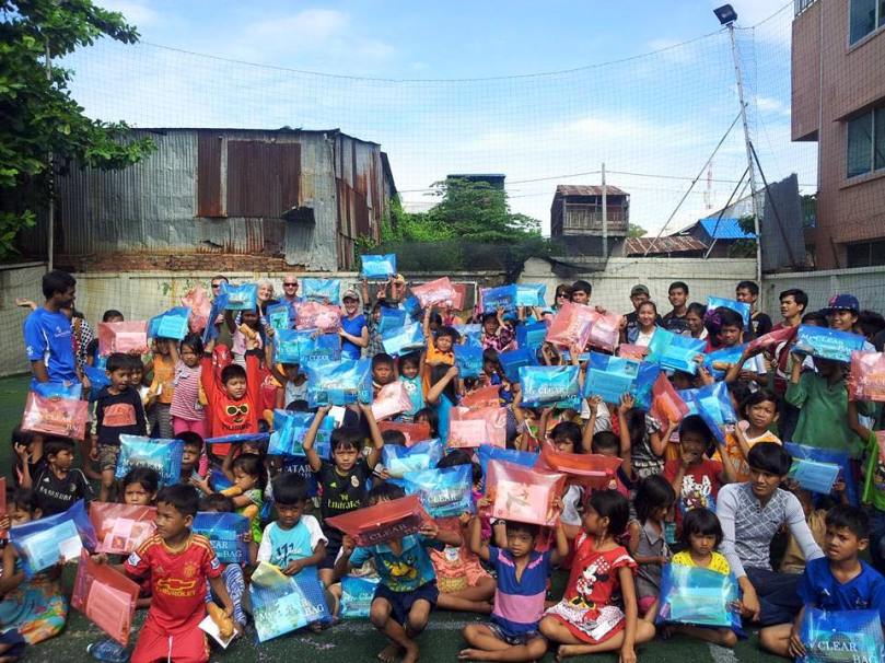 All the neighborhood children holding up their gifts of school supplies