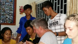 Looking at pictures on phones, having discussion around the table...